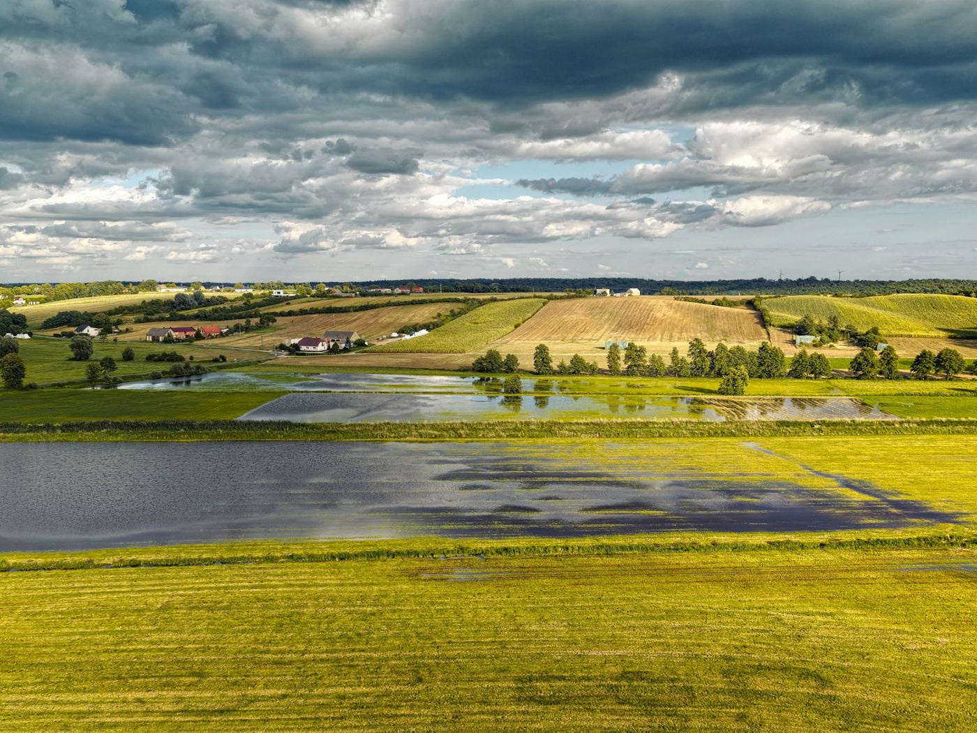 Flooded farmland with standing water across paddocks, recorded from the air