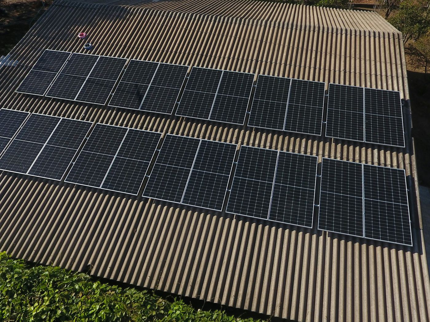 Solar array on a corrugated metal roof, seen close from a drone