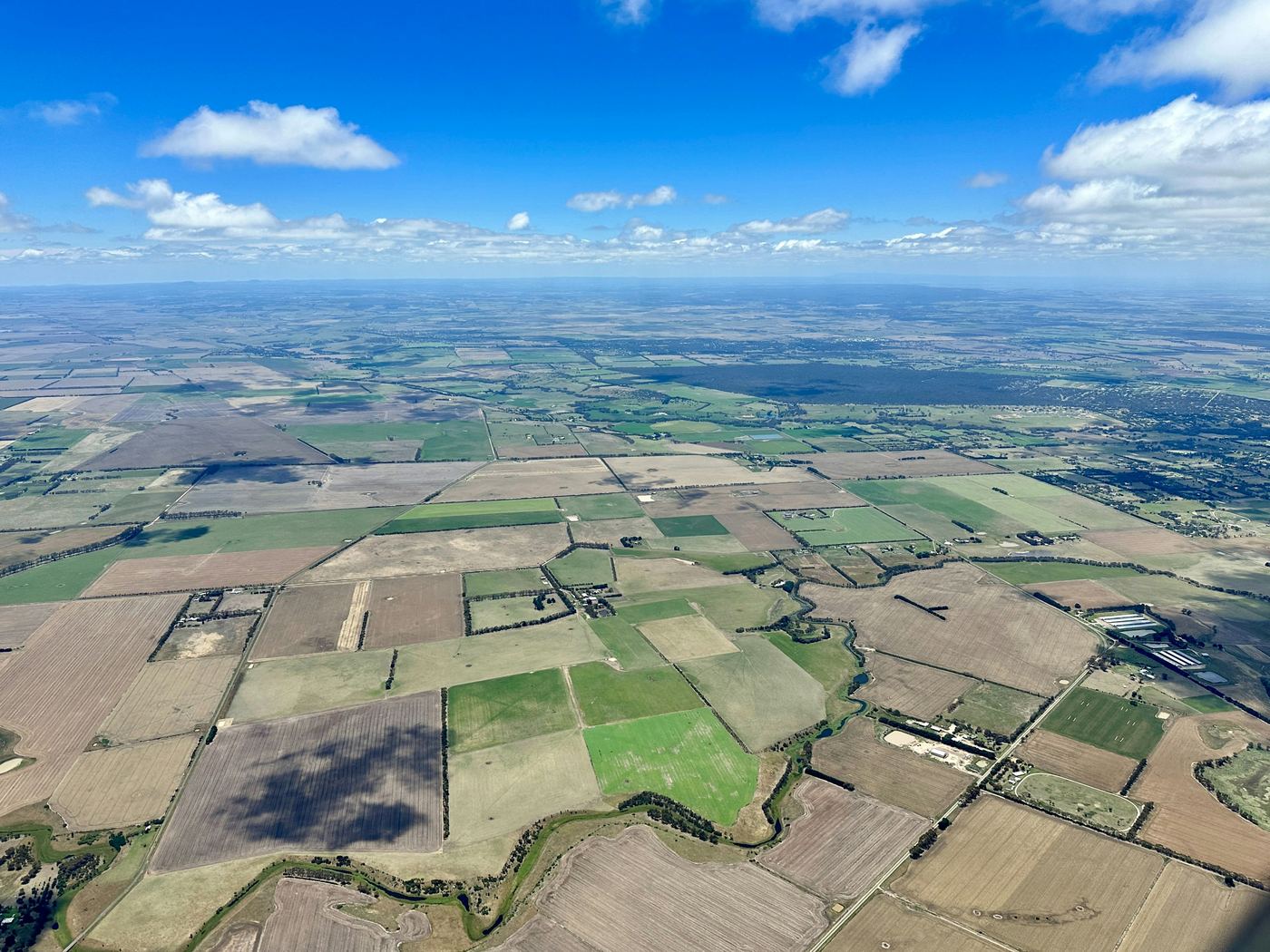Farmland paddocks, shelter belts and tracks from the air, the kind of ground a mapping flight covers