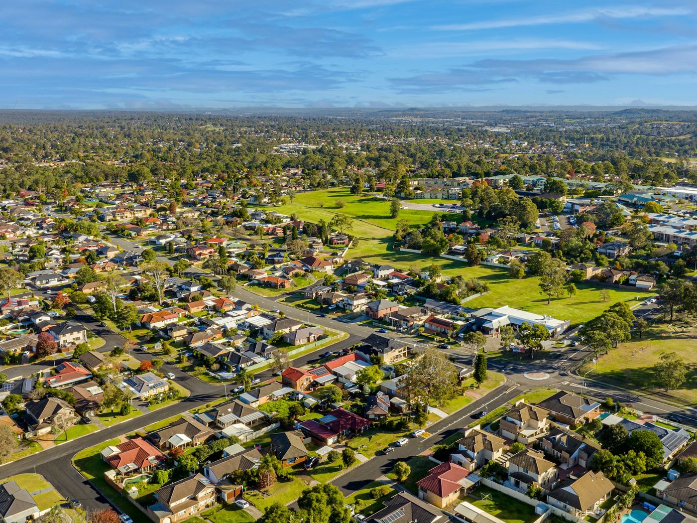 Established suburb of brick and tile homes, parkland and streets from the air